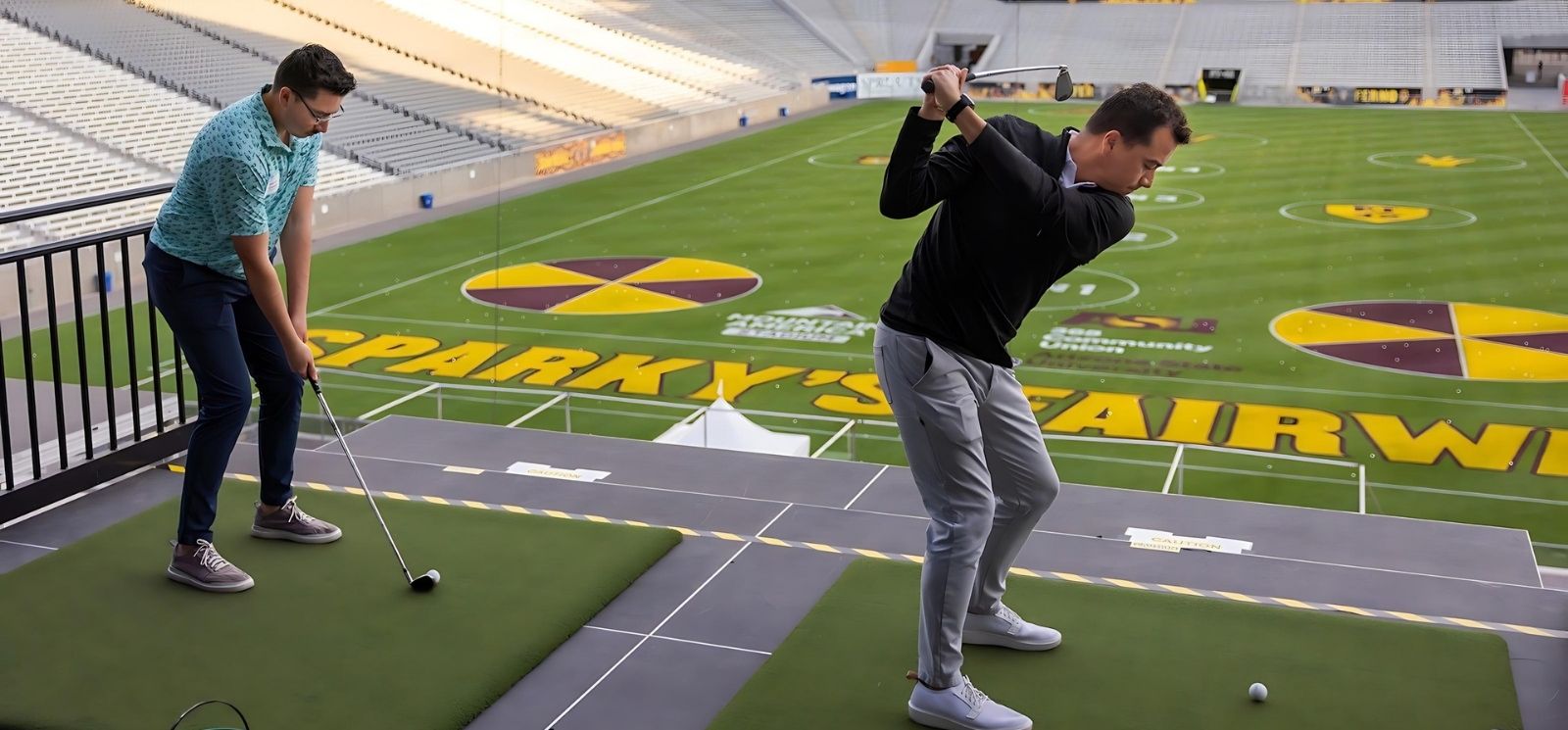 Two golfers prepare to take swing at Sparky's Fairway, inside the ASU football stadium