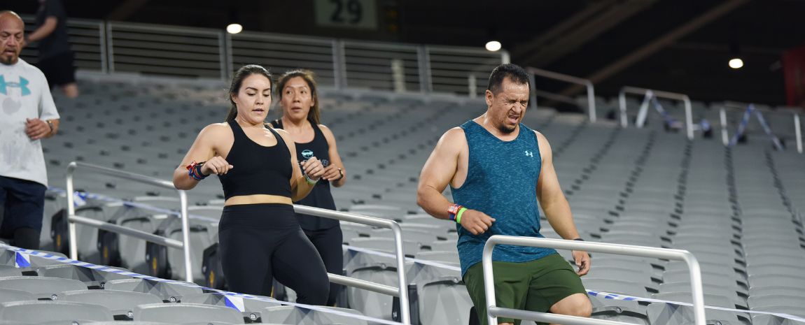 Three people running down stadium steps with intense facials expressions
