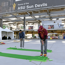 Two men playing putt putt on the Sparky's Fairway clubhouse