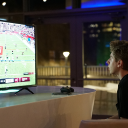 Student focused on the EA College Football 25 game