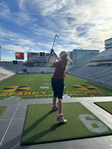 Woman in final golf stance at bay 6 at Sparky's Fairway