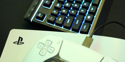 PlayStation controller on top of PS5 console with light up keyboard